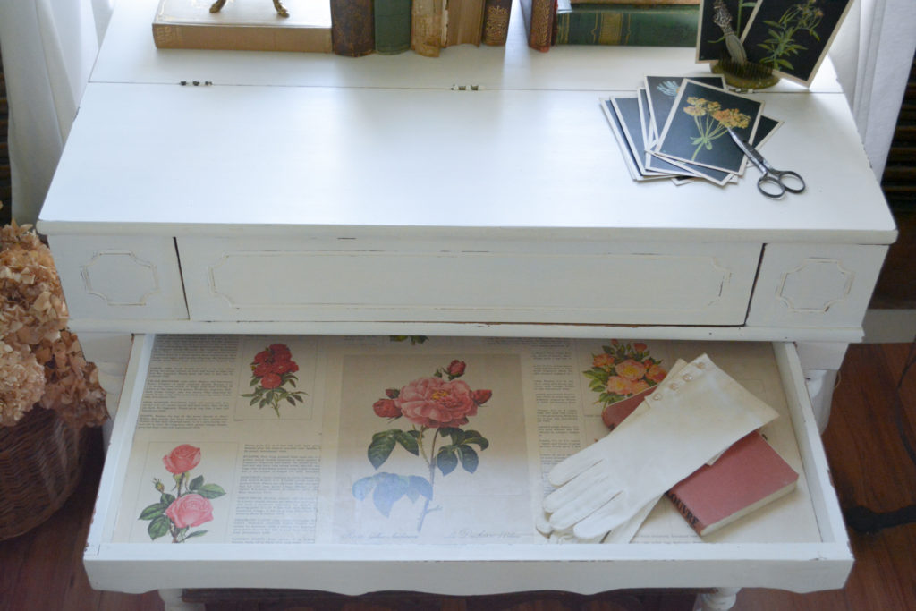 Spinet desk drawer lined with book pages, starched book pages