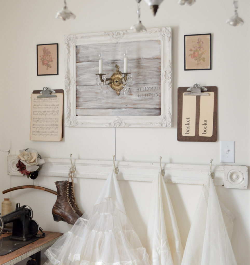 creative studio with vintage sconce mounted on reclaimed wood frame