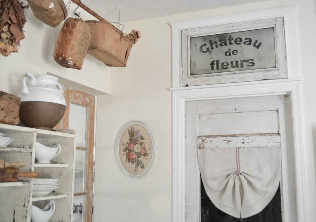 A DIY faux transom window with grain sack curtain on old door
