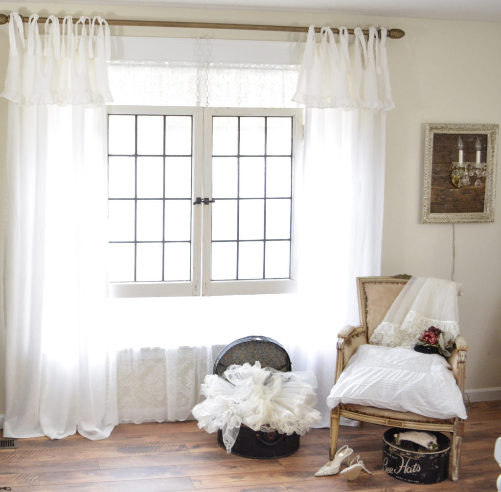 DIY antique brass finish curtain rod, tie top white curtains, and deconstructed french chair. 
