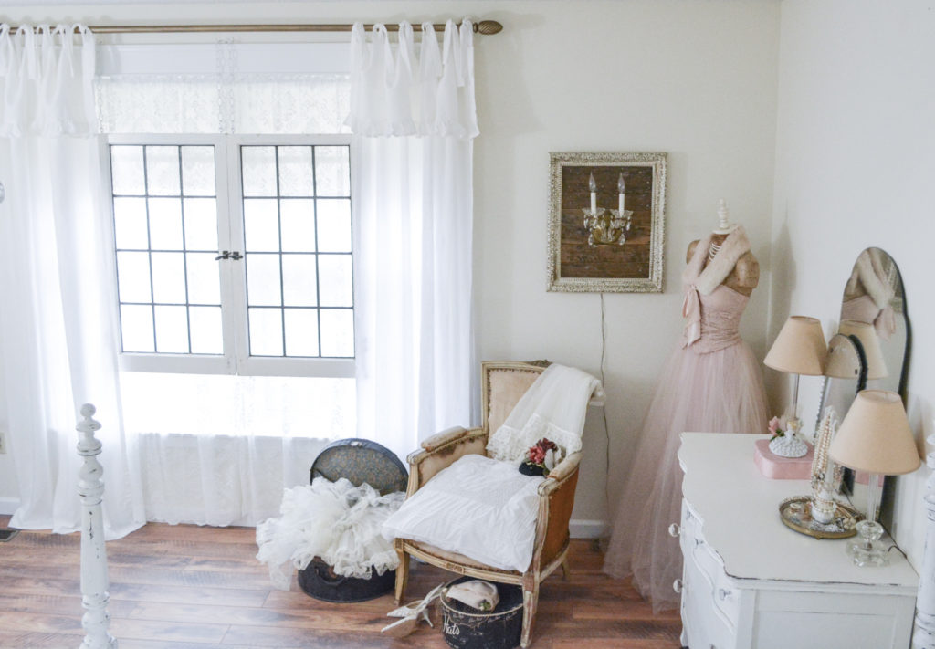 Romantic cottage style bedroom with tie top curtains and DIY antique brass curtain rod.