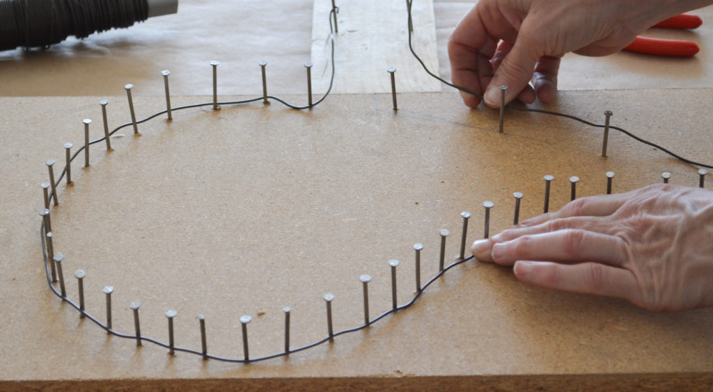 wrapping wire around a nail template to make angel wings