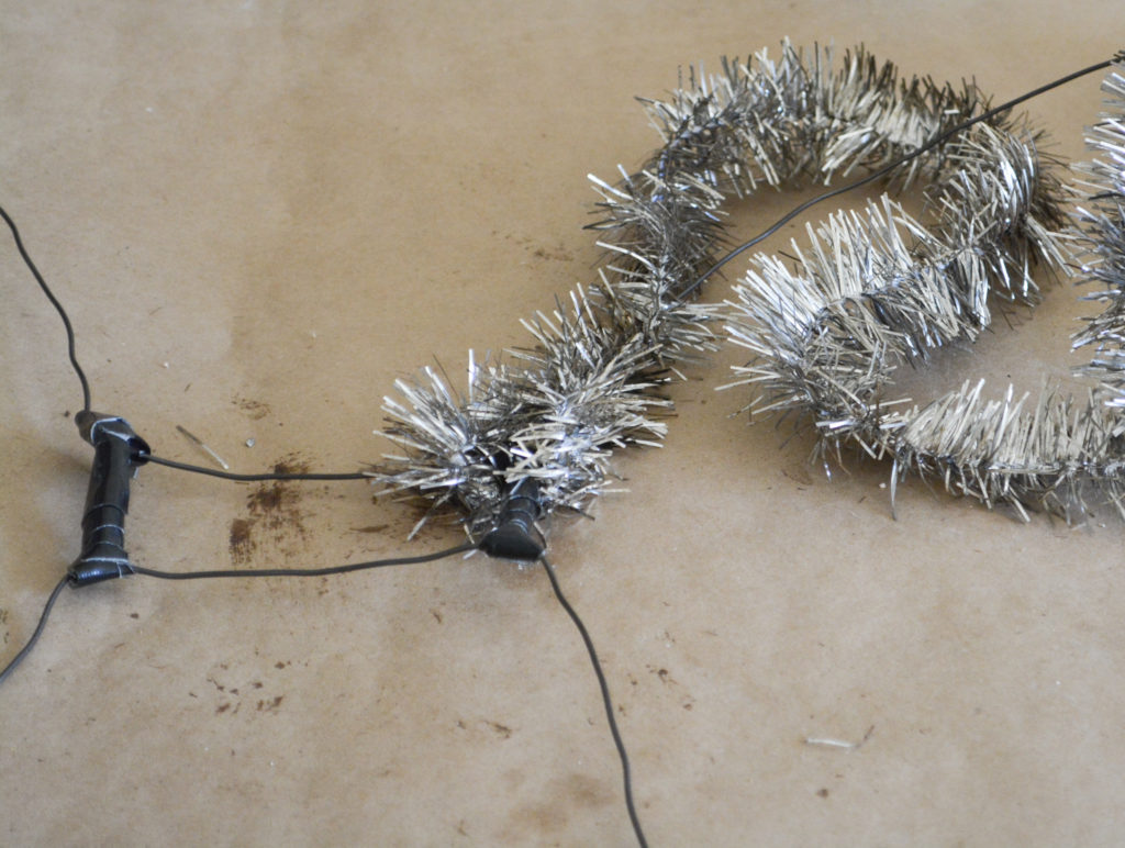 wrapping tinsel garland around diy wire angel wing