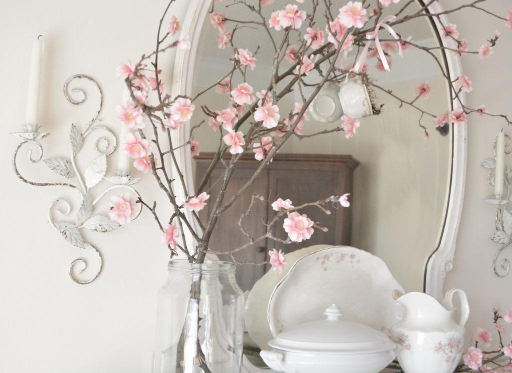 Spring flowering branch on antique fireplace mantel with tea cup birds nest