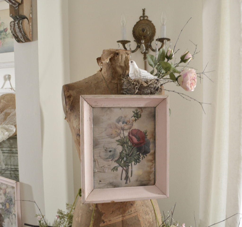 Dress form with vintage art and bird's nest