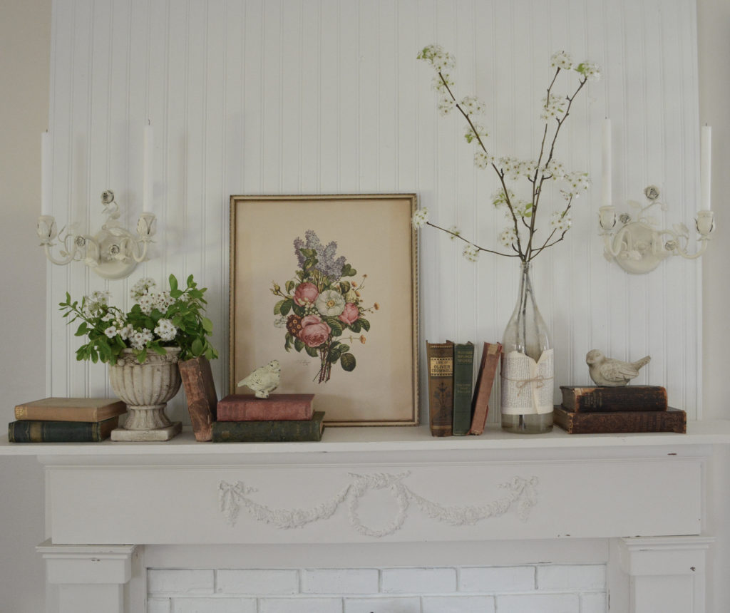 pear tree blossoms on mantel paired with old books and vintage floral print