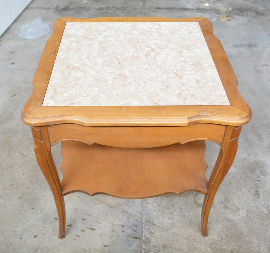 a french provincial table with a faux marble top