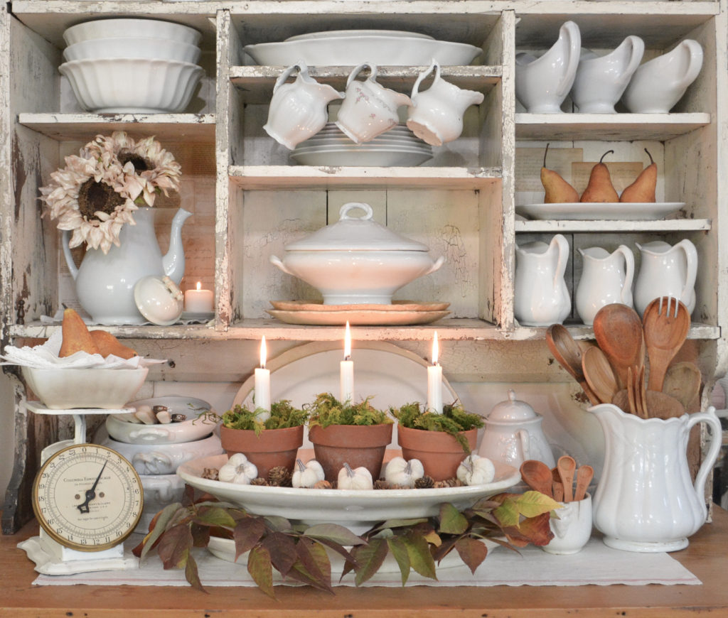 kitchen hutch filled with ironstone and decorated for fall