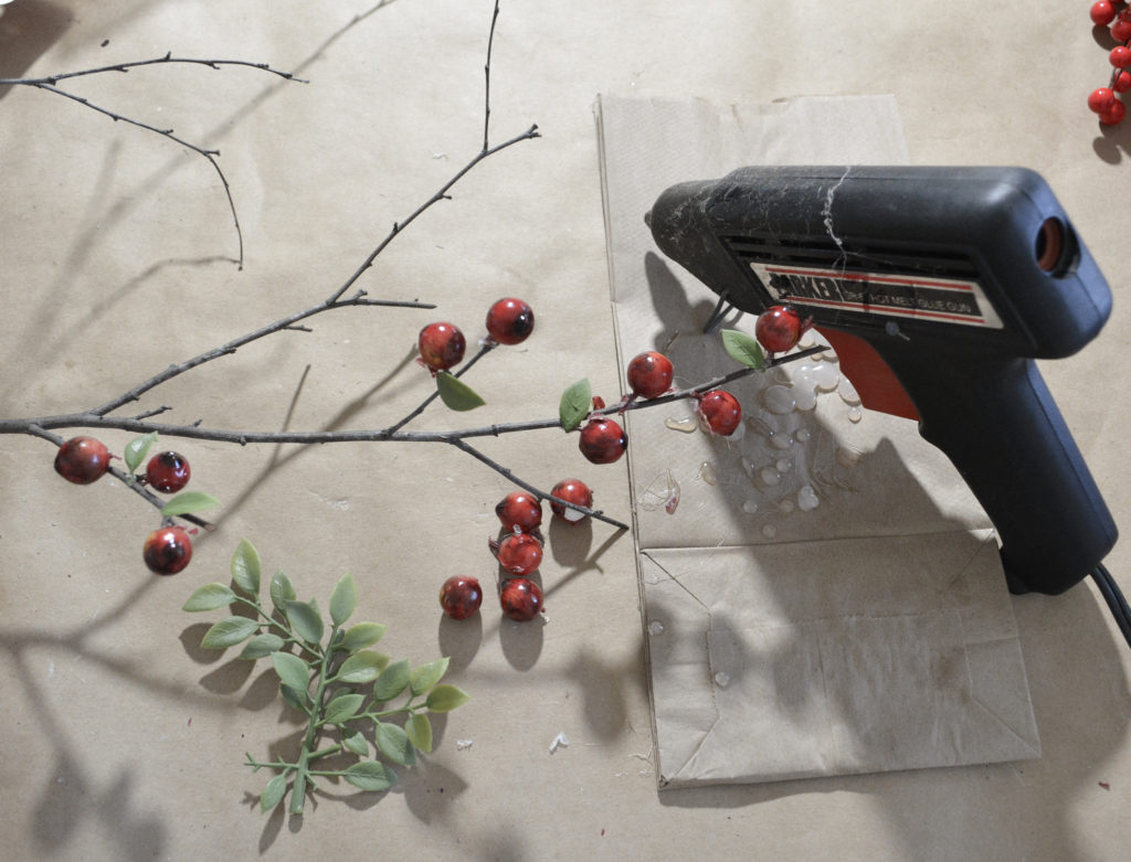 hot gluing faux berries to real tree branches