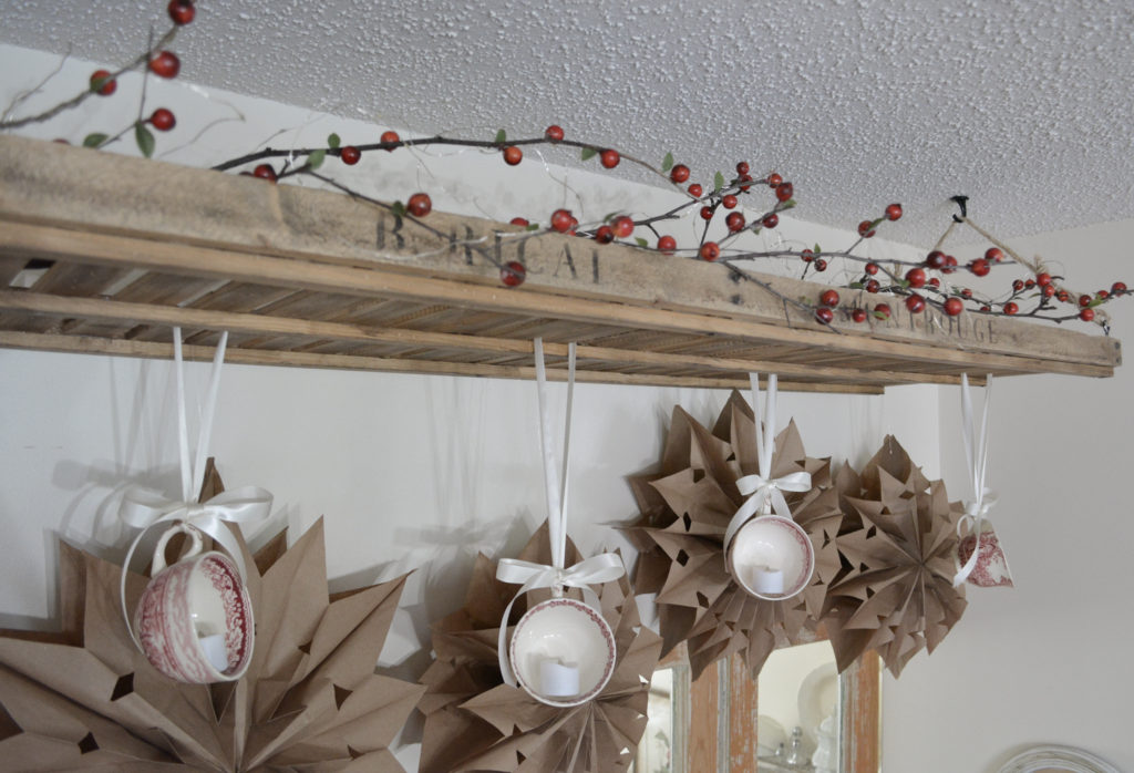 berry branches, tea cups, and paper bag stars on french drying rack