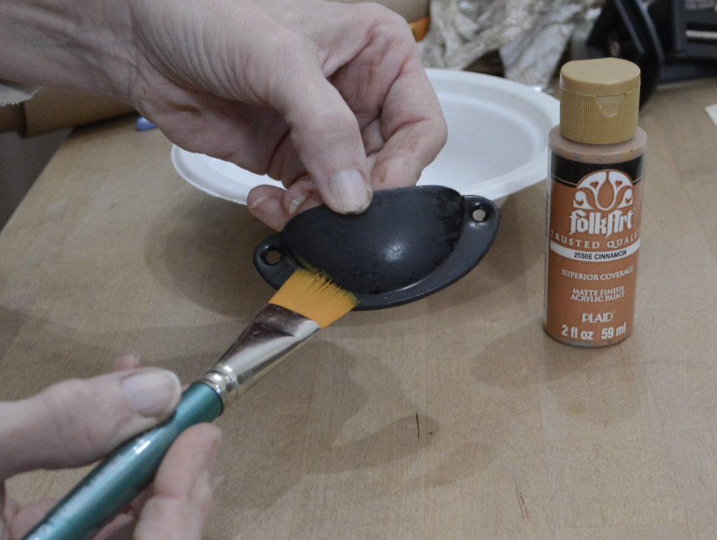 brushing on orange [paint to create rust finish