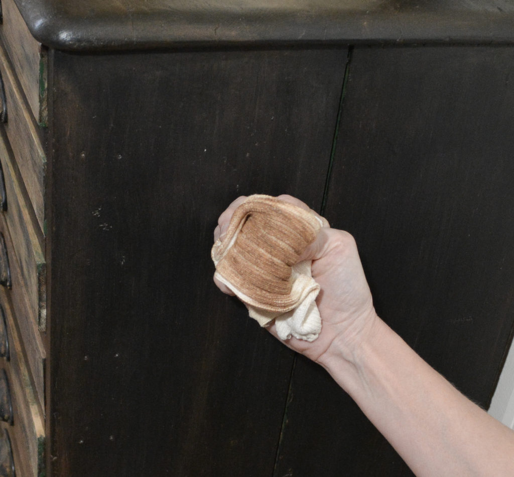 buffing the wax on a black cabinet