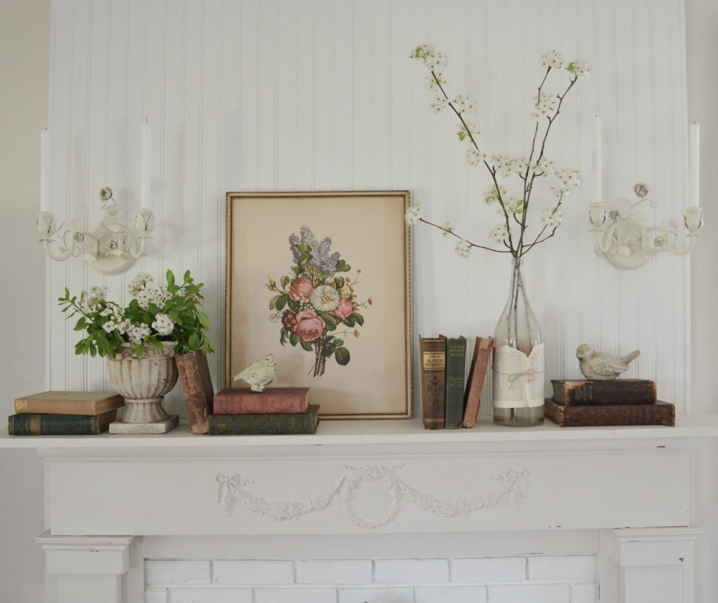 spring mantel decor with old books and flowering branches