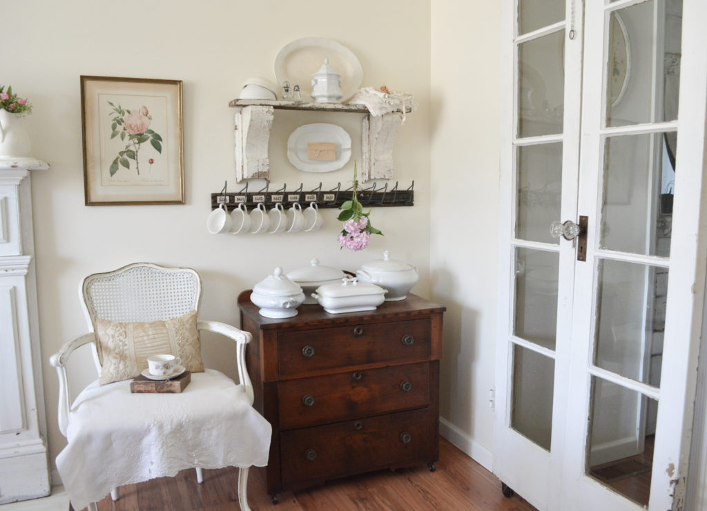 white cottage room with french doors and a french chair