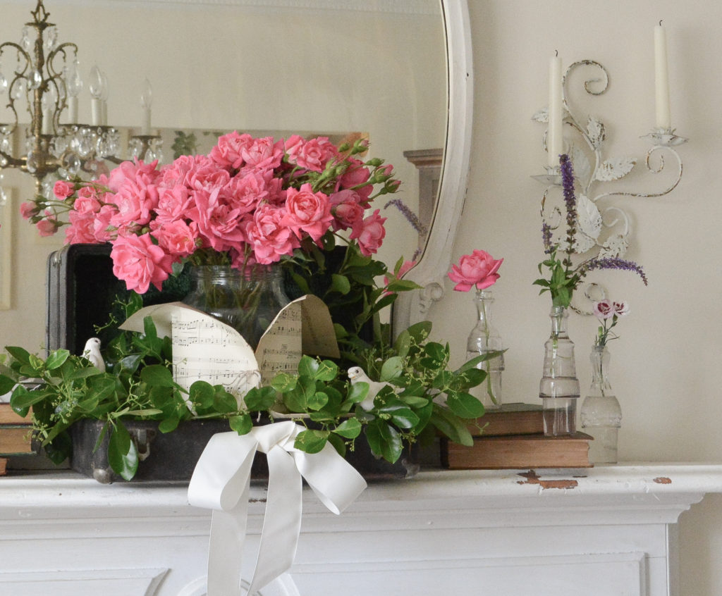 roses on mantel with sheet music wrapped vase