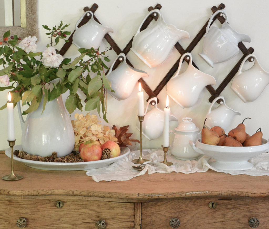 ironstone pitchers and antique hutch decorated for fall