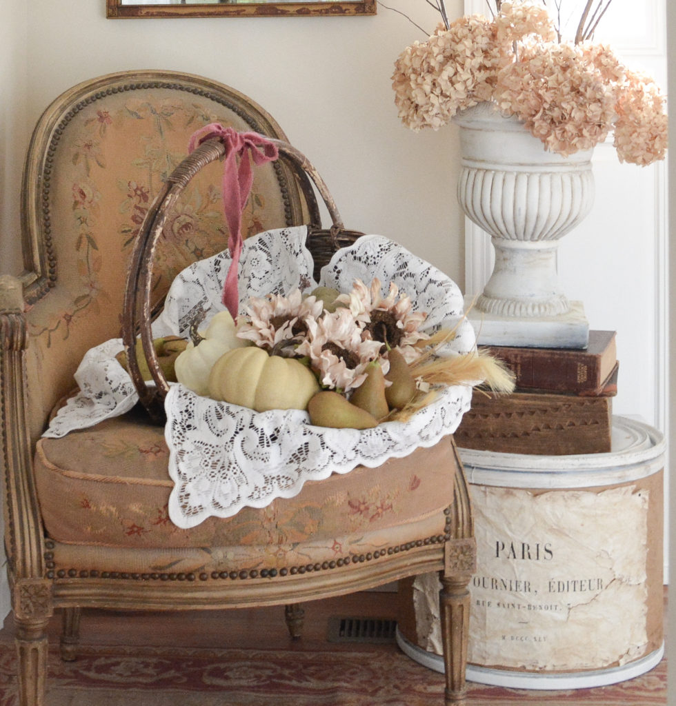 a gathering basket filled with falls bounty on an old french chair