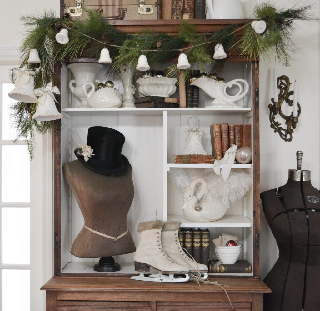 Spun cotton bell garland over a shelf with antique dress form