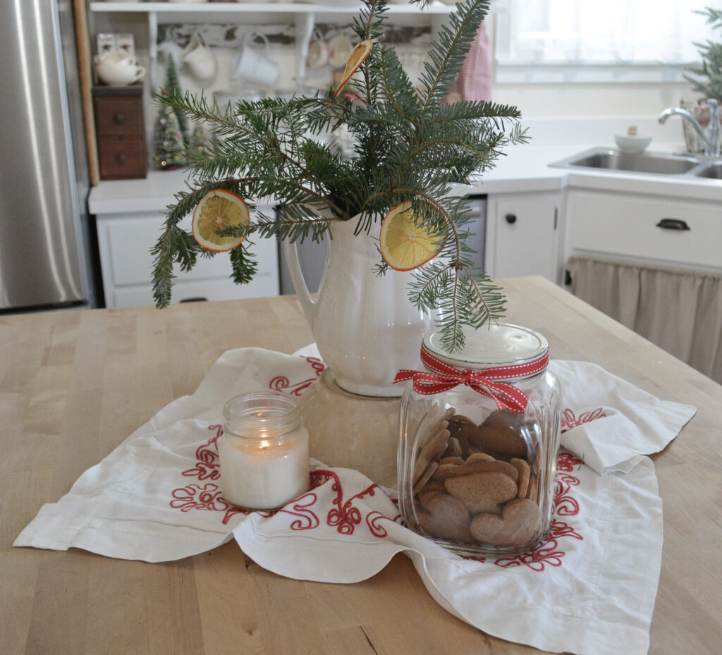 red and white needlework and greenery on kitchen island