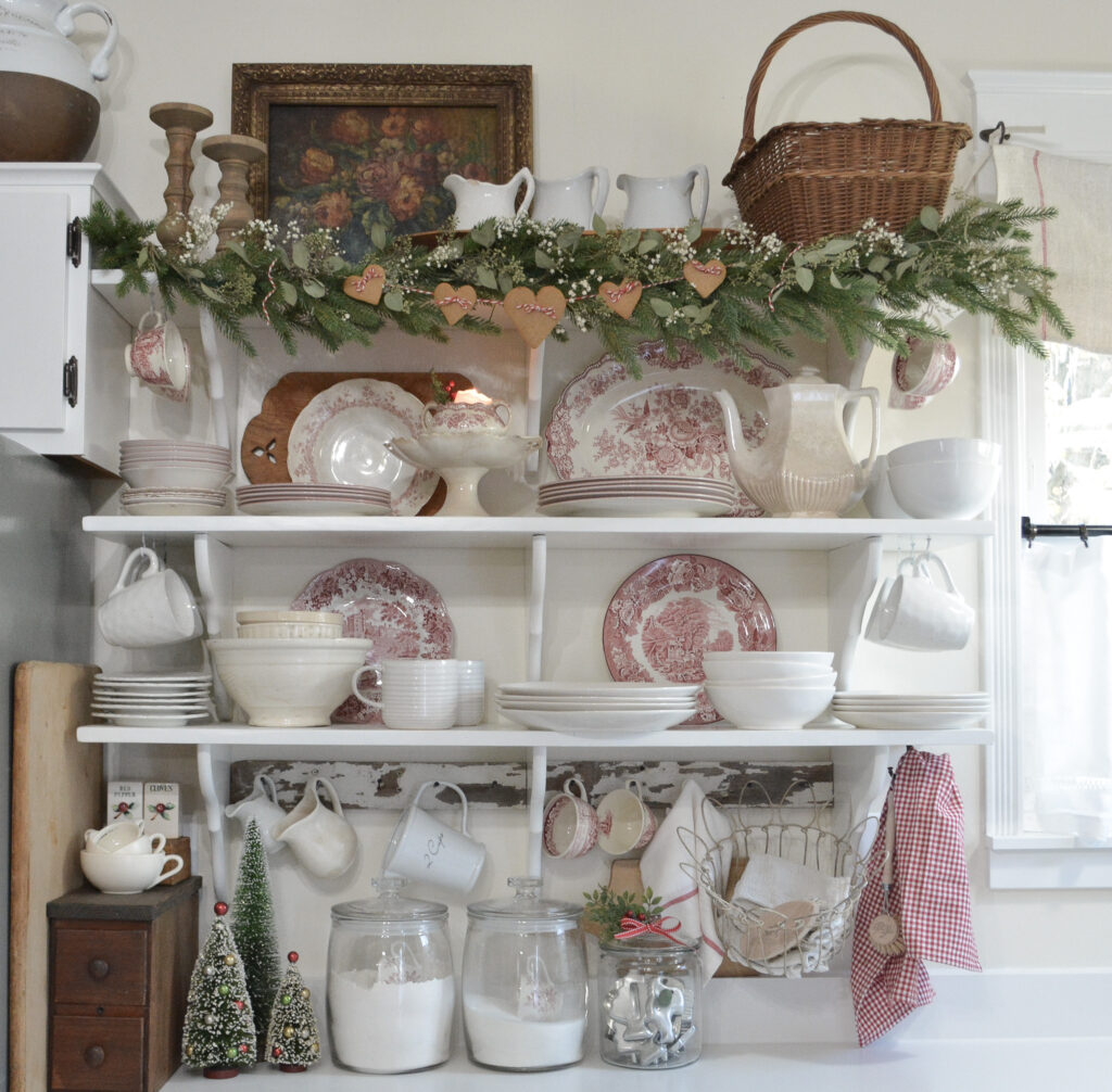 red transferware dishes on open kitchen shelves decorated for Christmas