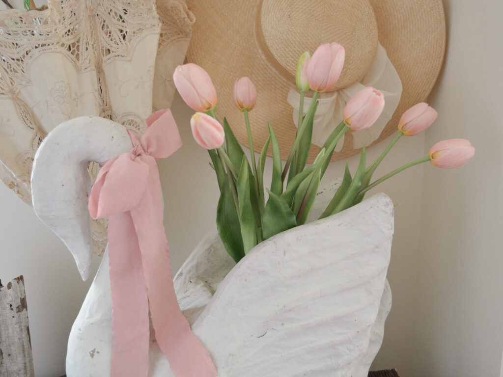 a swan planter filled with faux tulips