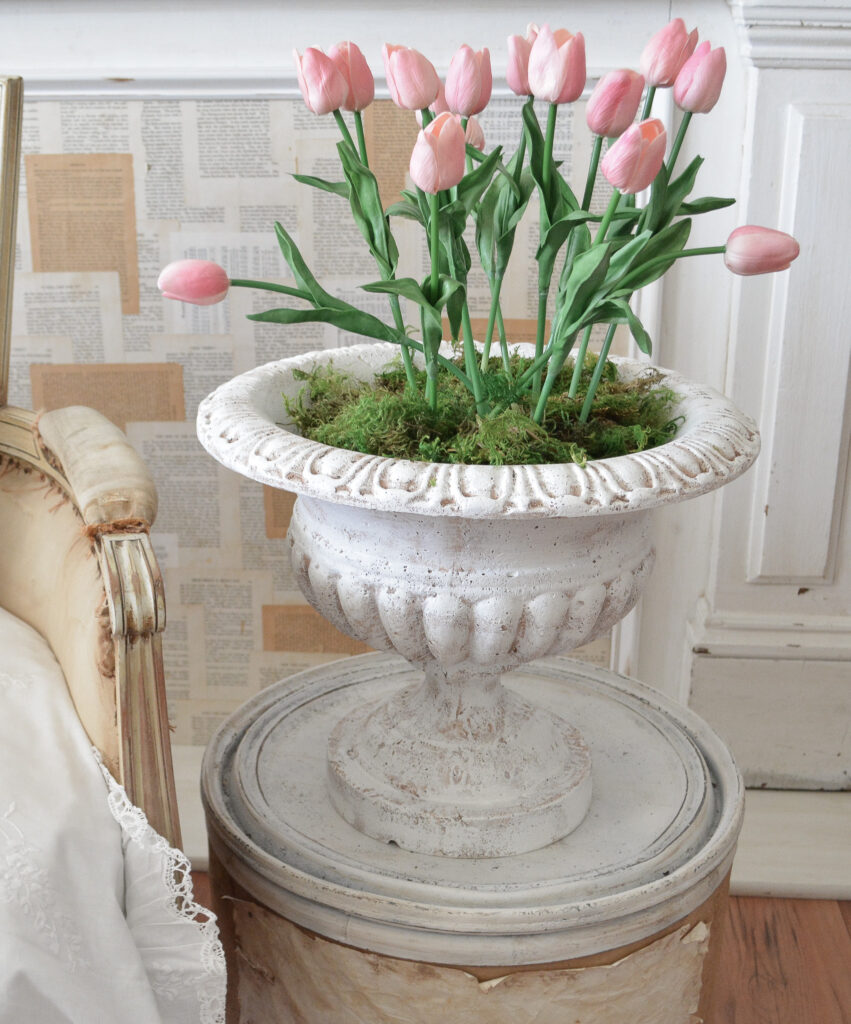 old urn filled with artificial tulips