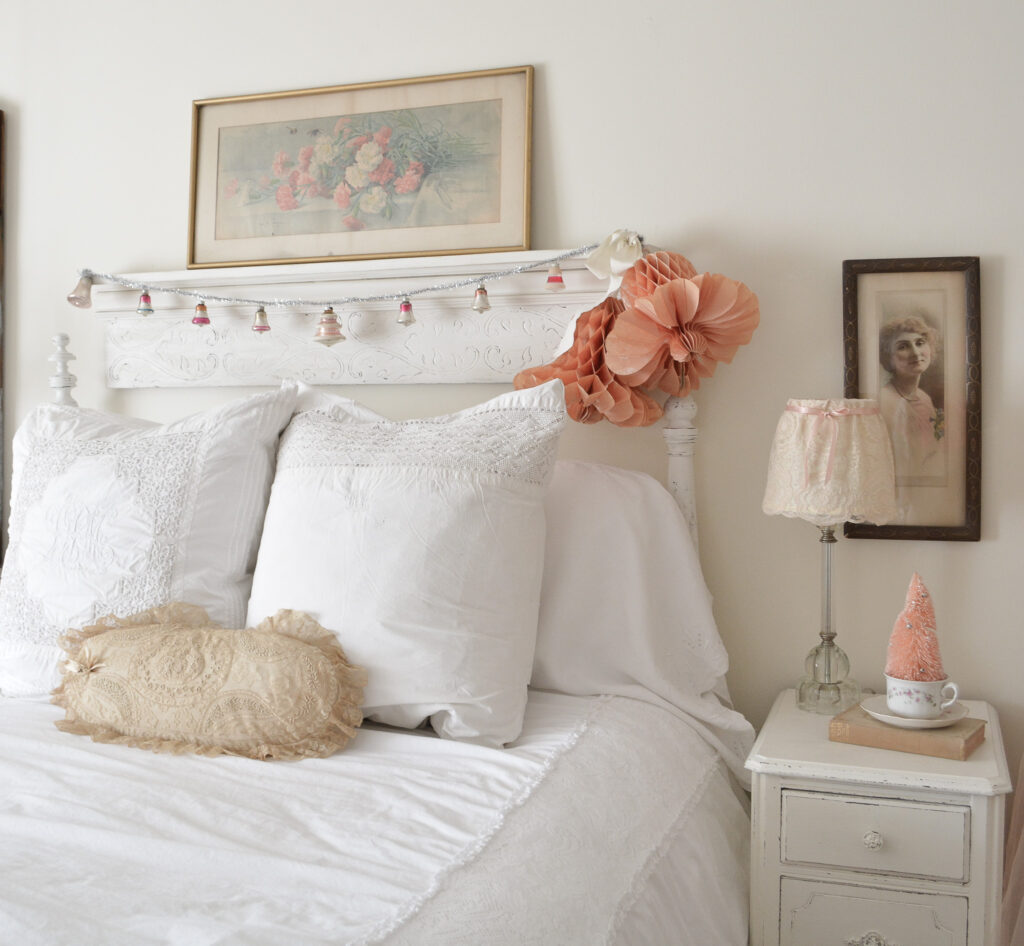 a vintage bell garland hangs over an antique bed